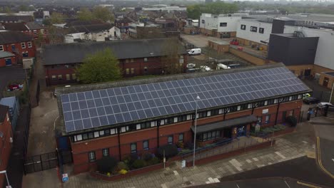 British-town-police-station-with-solar-panel-renewable-energy-rooftop-aerial-view-orbiting-left