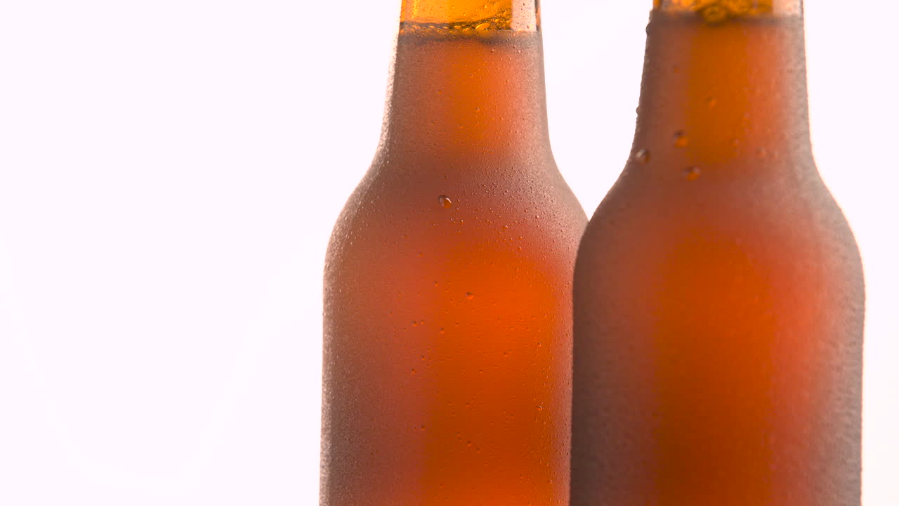 Two beer bottle rotating on white background