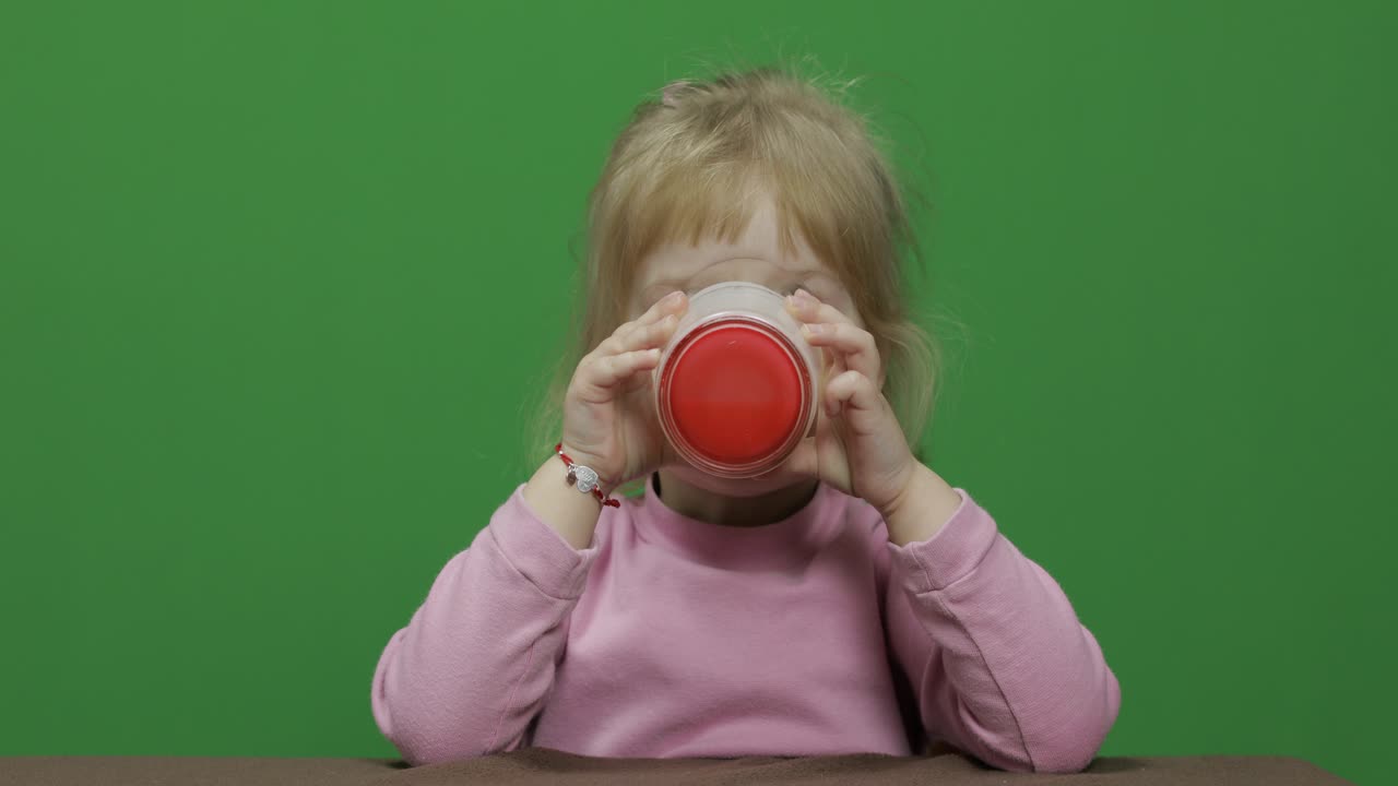 chica sentada en la mesa y bebiendo leche de yogur. bigote de leche gracioso
