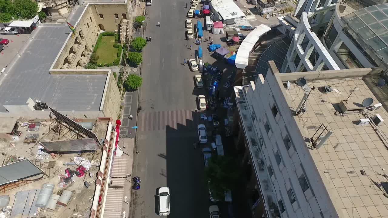 Una veduta aerea della città di Erbil che mostra l'antica Cittadella di Erbil e il giardino di fronte al castello con fontane d'acqua e il popolare mercato