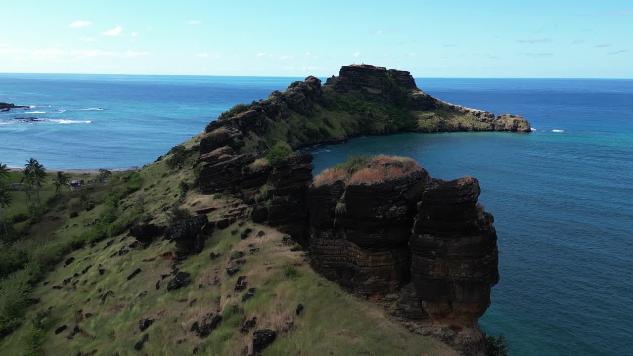 Aerial view of dramatic cliffs surrounding a deep blue bay on a tropical island