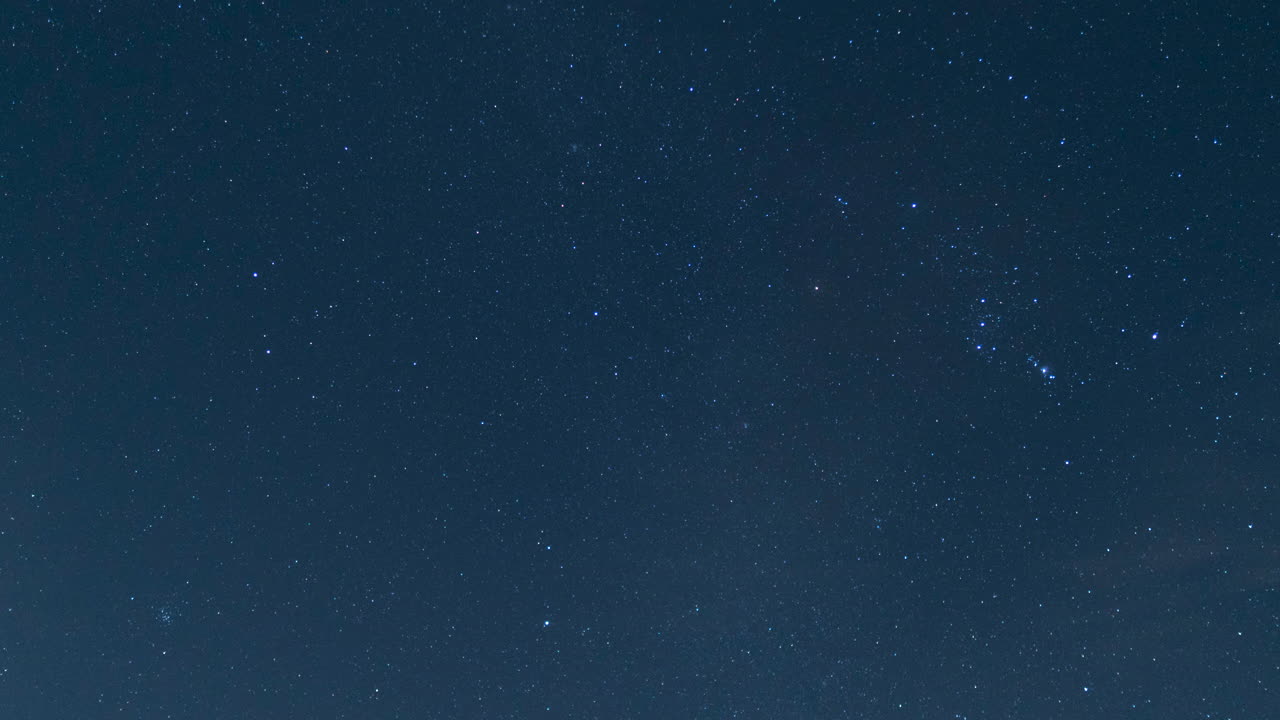 이 야간 저속 촬영에서 희미한 구름이 지구와 하늘의 별 사이를 날아갑니다.