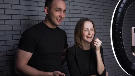 video of blogger couple with smartphone on brick wall background