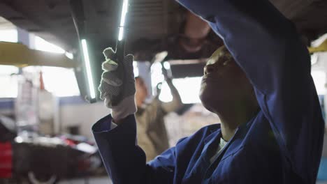 Video-of-african-american-female-car-mechanic-checking-car