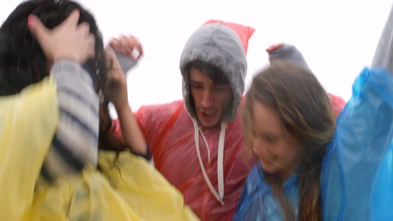 amigos divirtiéndose bajo la lluvia.