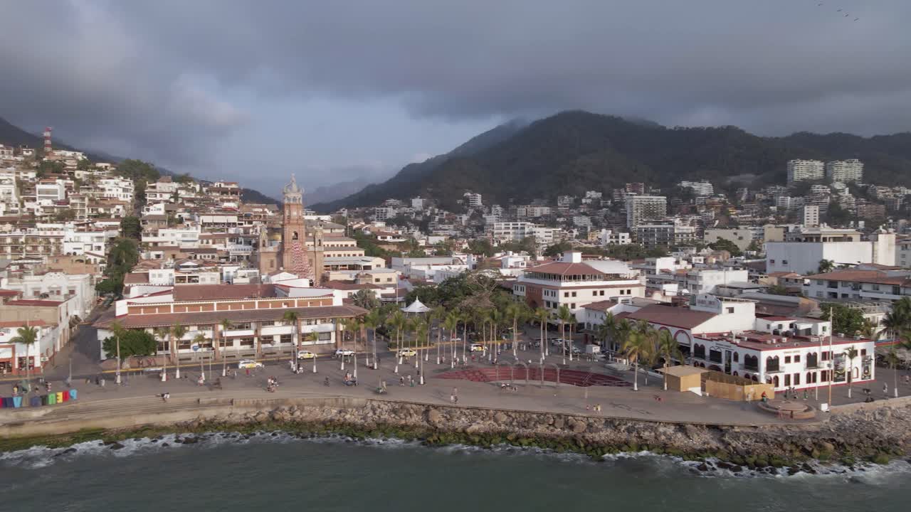 Low aerial pans with traffic along Puerto Vallarta waterfront esplanade