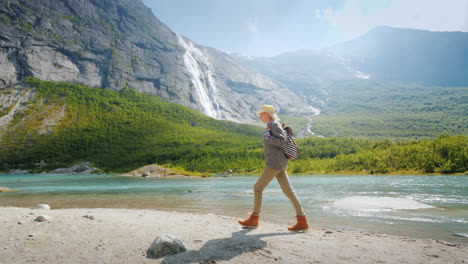 A-Tourist-Woman-Walks-Alone-Surrounded-By-Majestic-Nature---Mountains-With-Waterfalls-On-Top-The-Tra