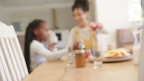 Happy-african-american-parents-and-daughter-having-breakfast-at-home,-slow-motion