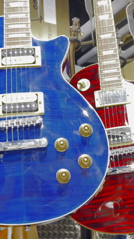 a store of colorful electronic guitars hangs on the wall. bass guitar. creating rock music.