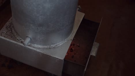 hand opening ash drawer of a wood stove