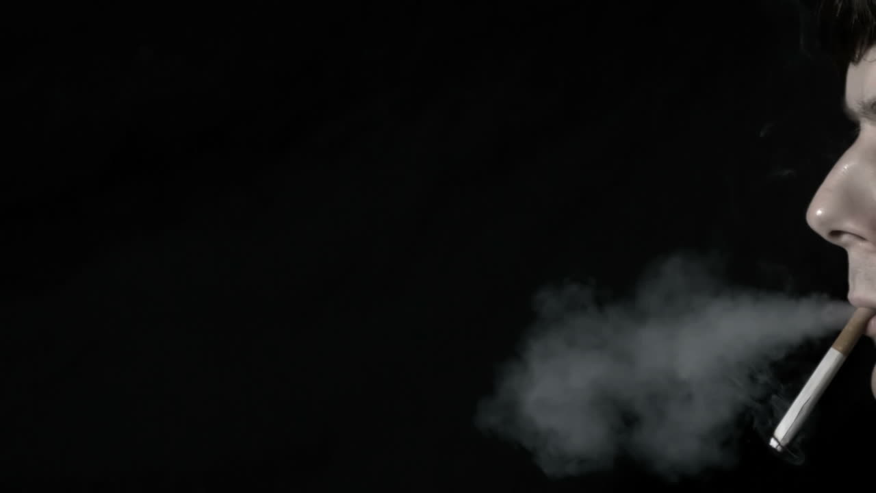 담배를 피우고 숨을 내쉬는 남자