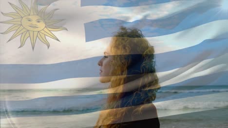 composición digital de ondear la bandera de uruguay contra las olas en el mar