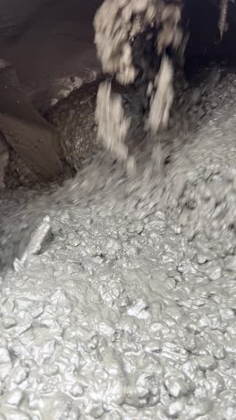 blades on a concrete mixer machine mixing a fresh pour on a construction site, vertical shot.