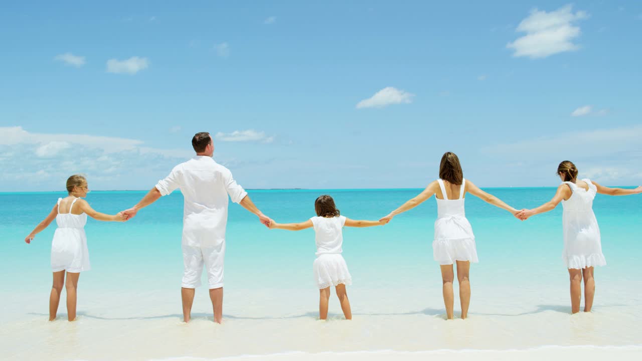 백인 부모 와 그 들 의 여자 자녀 들 이 해변 을 즐기고 있다