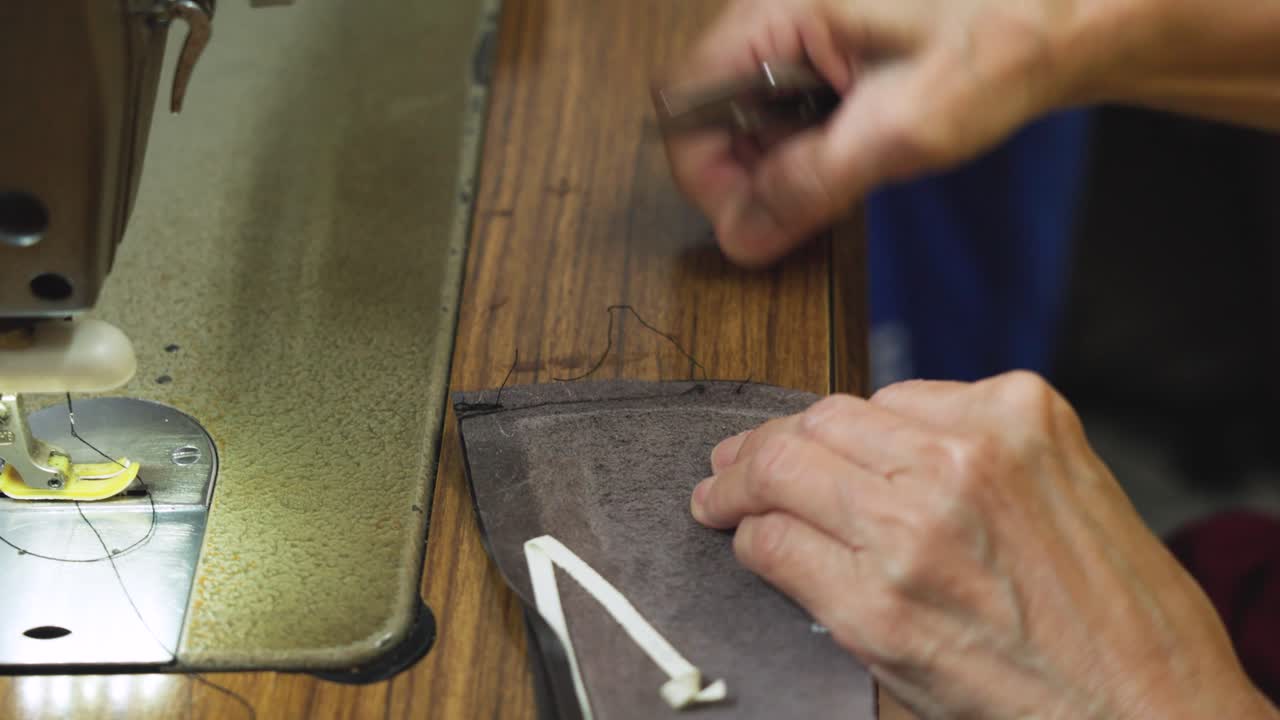 Close-up of removing a thread from a shoe vamp in Malaysia. Skilled hands carefully undo stitching, highlighting the repair process, precision work, and traditional cobbler craftsmanship. UHD
