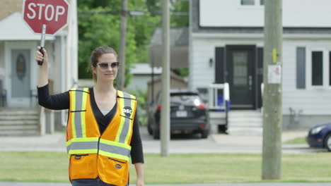 tilt up to female crossing guard walking across the street