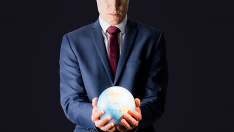 businessman holding glowing globe in his hands on grey background