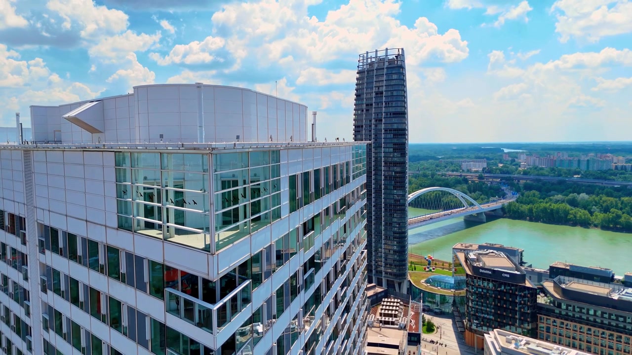 Bratislava, Eslováquia, 2 de junho de 2026: Vista da paisagem urbana do telhado de um edifício alto, Bratislava, Eslováquia. Torres modernas, o rio Danúbio e uma ponte em arco branca sob um céu nublado.