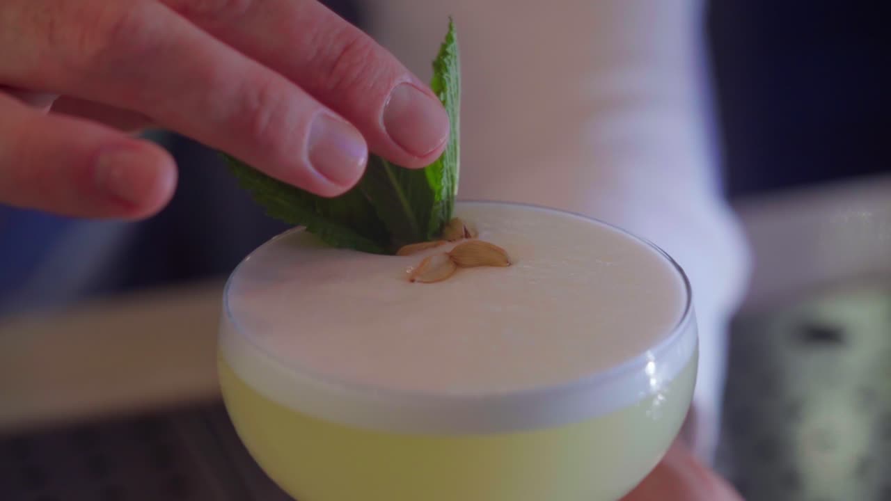 camarero prepara un cóctel con menta