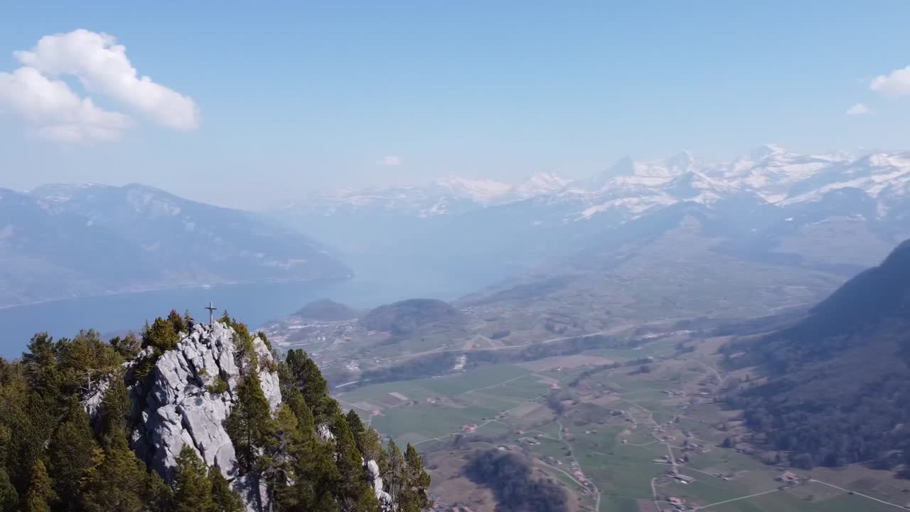 Circling around a mountain peak with the beautiful Lake Thun and the Swiss mountains in the background, in nice weather.