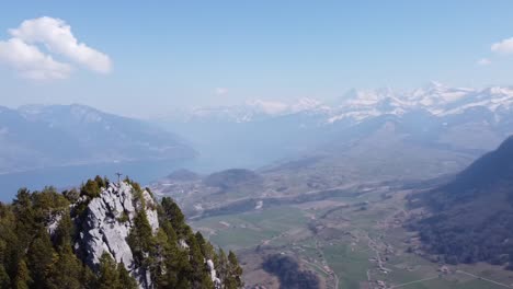 circling around a mountain peak with the beautiful lake thun and the swiss mountains in the background, in nice weather.