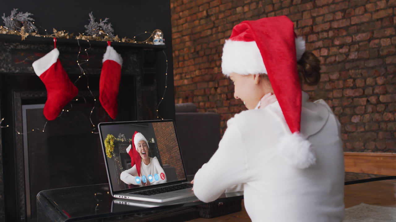 산타 모자를 입고 집에서 시간을 보내는 백인 여성