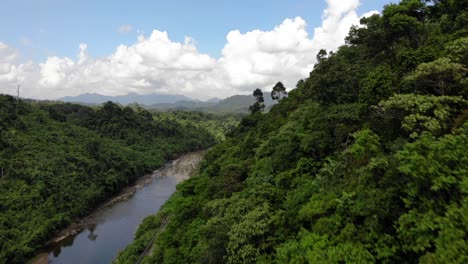 Wide-Aerial-Dolly-moving-close-over-a-hill-ridge-at-Quang-Nam-Province,-Vietnam