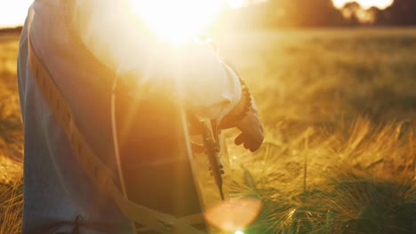 Musician-playing-guitar-in-field-slow-motion-strumming-strings