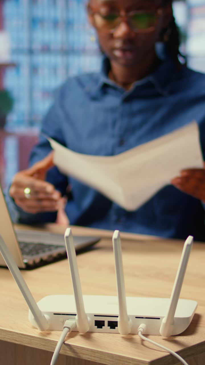 Wireless Internet Router on Desk with Woman Working on Laptop