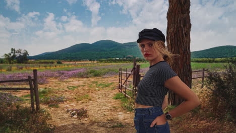 4K-UHD-Cinemagraph-of-a-young-brunette-woman-with-a-watch-standing-by-a-field-of-flowers-in-Tuscany,-Italy