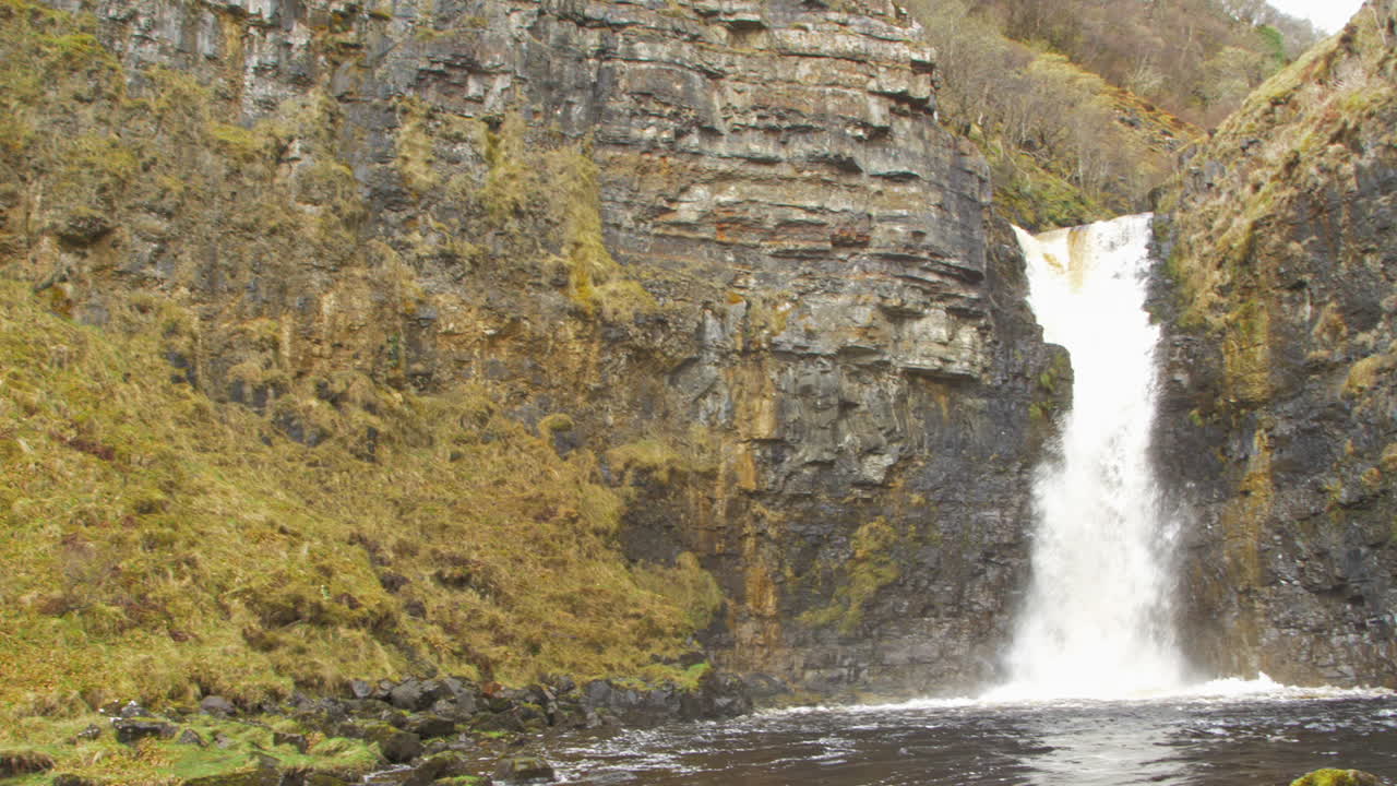Waterfall in Scotland with a nice view on the Landscape