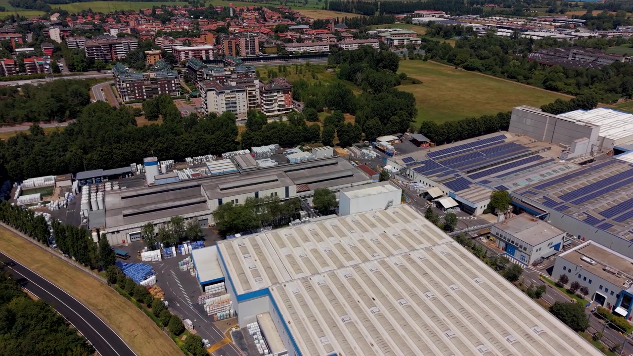 Stor fabrik, der producerer byggekemikalier i Norditalien, set ovenfra med industribygninger og produktionsområder
