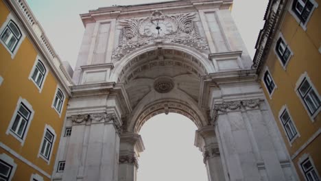 tilt up towards an arch in lisbon portugal with statue in background