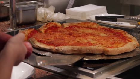 close up shot of taking a piece of freshly baked pizza, italian pizza on msc cruise