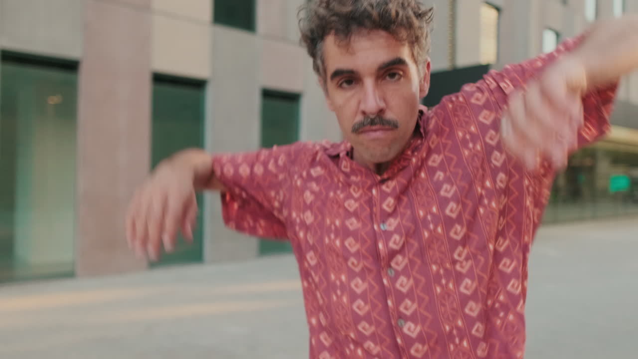 Jovem com Bigode e Piercing no Nariz Dançando Expressivamente ao Ar Livre