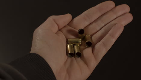 hand opening and revealing 9mm bullet shell cases