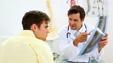 Young-doctor-showing-xray-to-his-patient