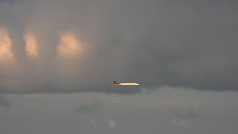 Passenger-airplane-flying-in-the-clouds-in-pink-shades