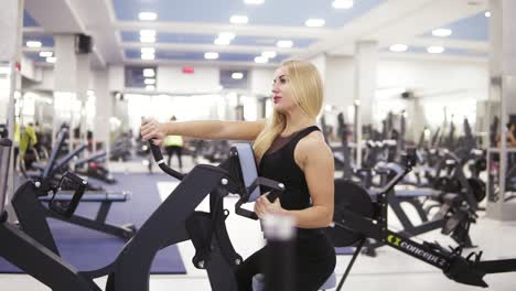 young female bodybuilder in black sportswear doing exersices at the gym. building up strong core and arms muscles. fitness and healthcare