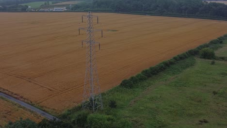 Strom-Stahlmast-Hochspannungsdrähte-Auf-Dem-Land-Landwirtschaftlichen-Bauernhof-Feld-Luftaufnahme-Am-Frühen-Morgen-Rechte-Umlaufbahn-Langsam