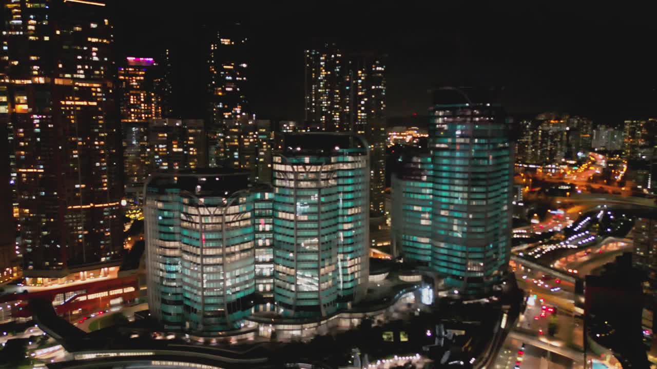 Drone footage of Hong Kong at night. Showcasing glowing skyscrapers, bustling streets, and city lights. Ideal for travel, urban, and skyline projects highlighting nighttime energy