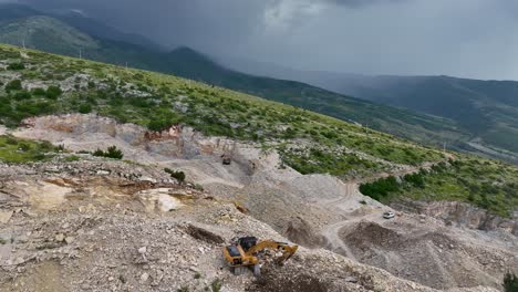 excavator digging and clearing rocks on the side of the mountain