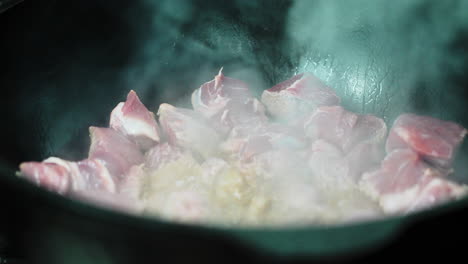 cooking cubed beef in a cast iron pot