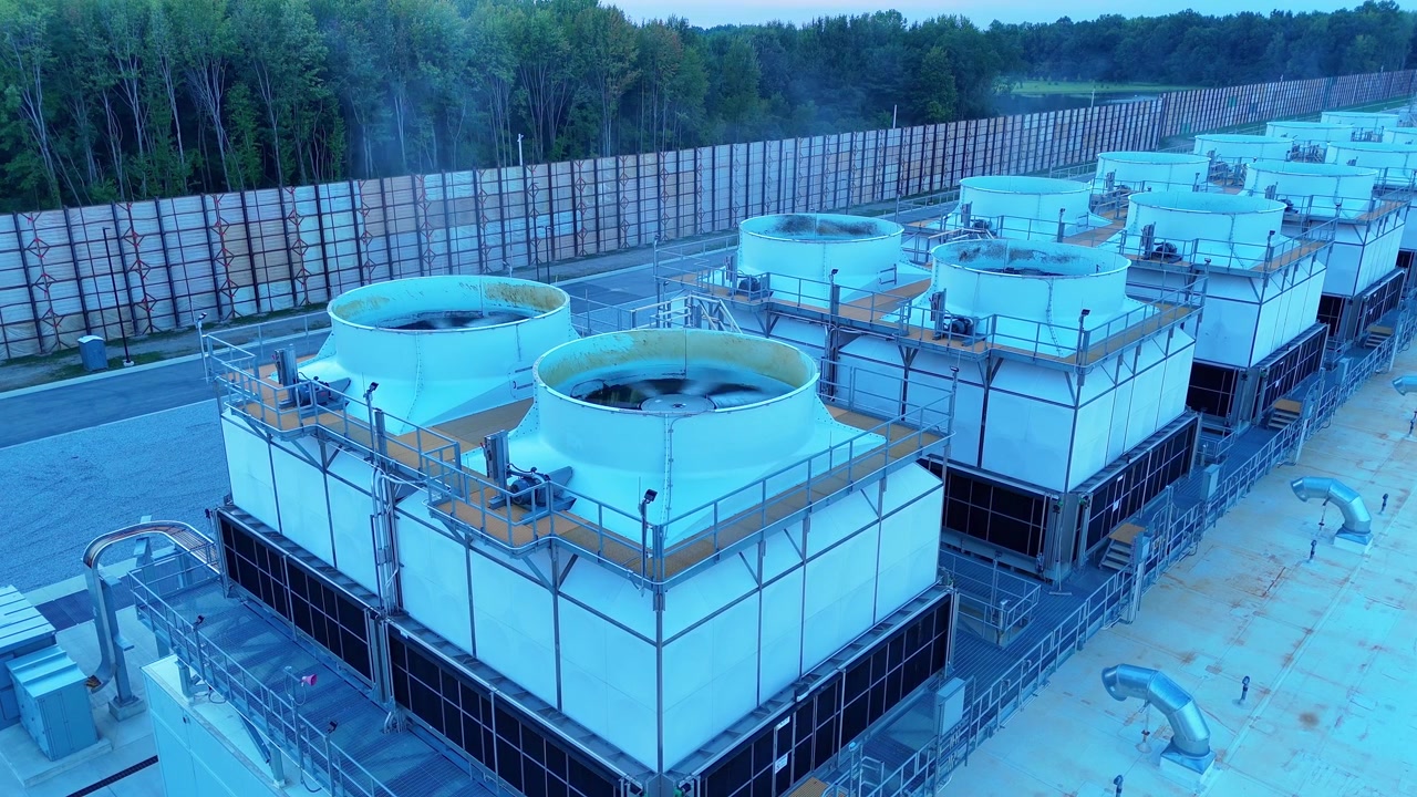 Industrial cooling units at a large data center campus releasing water vapor for heat exchange