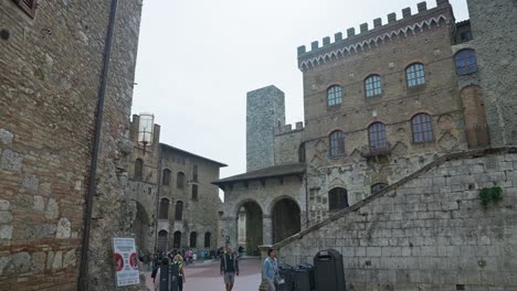 Plaza-De-La-Ciudad-De-La-Piazza-Del-Duomo-Con-Gente-Que-Viaja-Durante-El-Día-En-San-Gimignano,-Italia