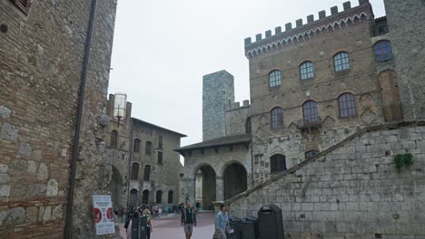 plaza de la ciudad de piazza del duomo con personas que viajan durante el día en san gimignano, italia