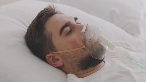 Sick-Man-Lying-On-Bed-Taking-His-Oxygen-Mask-Off-And-Coughing-2