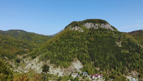 montaña con bosques verdes cerca del pueblo alpino con centros vacacionales en dardha, albania