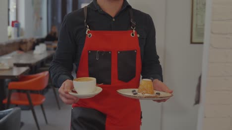 waiter serving coffee and cake in a cafe