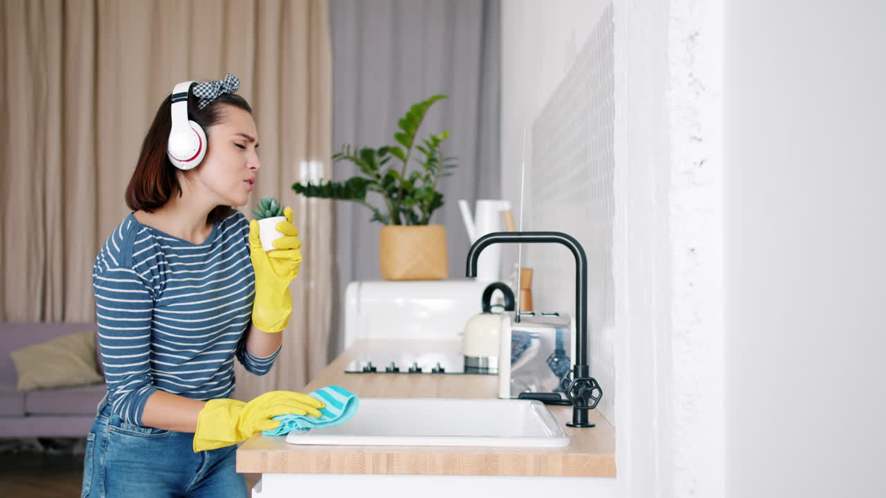 Woman Cleaning Kitchen with Headphones